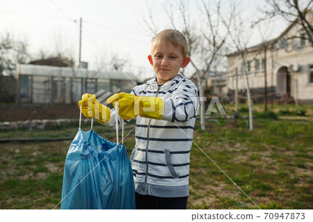 little boy in the park collect plastic bottles little boy in the park collect plastic bottles 70947873