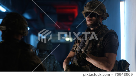 Male commander with gun giving orders to SWAT team 70948009