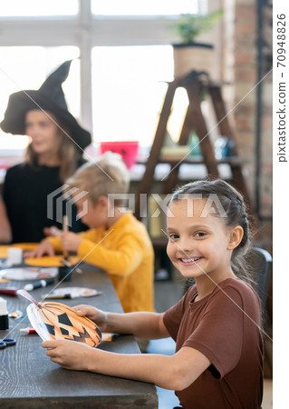 Pretty girl making Halloween pumpkin craft Pretty girl making Halloween pumpkin craft 70948826