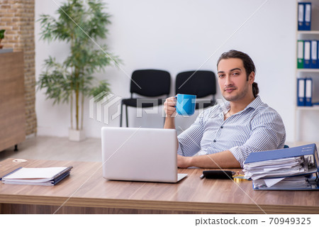 Young male bookkeeper working in the office Young male bookkeeper working in the office 70949325