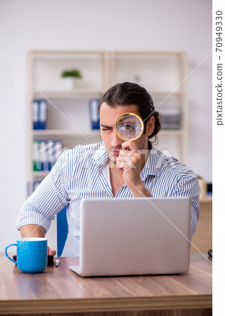 Young male bookkeeper working in the office Young male bookkeeper working in the office 70949330