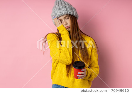 Redhead woman holding disposable cup of coffee 70949610