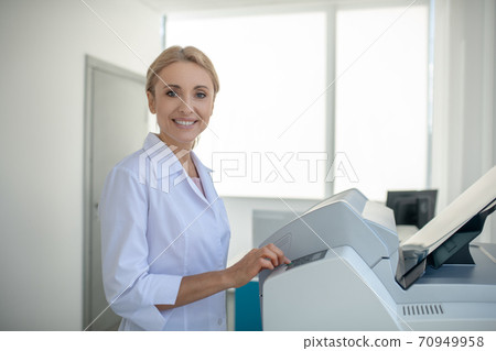 Fair-haired young doctor looking busy at work and smiling 70949958