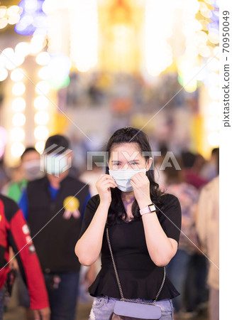 Asian female wear surgical mask while travel in night market new normal travel lifestyle in Thailand 70950049