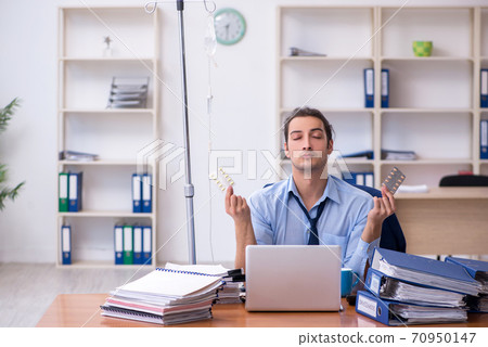 Young male employee suffering at workplace Young male employee suffering at workplace 70950147