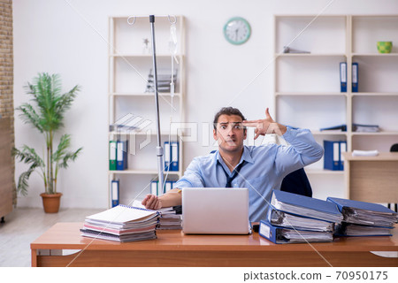 Young male employee suffering at workplace Young male employee suffering at workplace 70950175