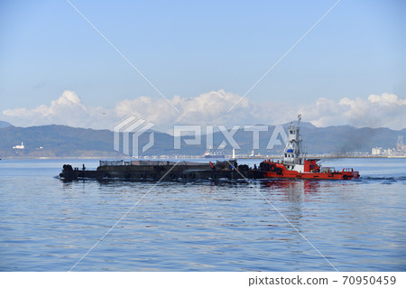 Photographing the work scenery of a tugboat carrying a pontoon at Hakodate Port, Hakodate City, Hokkaido in autumn Photographing the work scenery of a tugboat carrying a pontoon at Hakodate Port, Hakodate City, Hokkaido in autumn 70950459