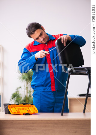 Young male contractor repairing furniture in the office 70951032