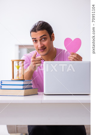 Male student in love preparing for exams in time management conc Male student in love preparing for exams in time management conc 70951104