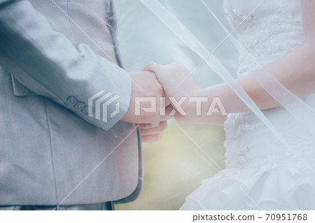 Married bride and groom holding hands as a symbol of love 70951768