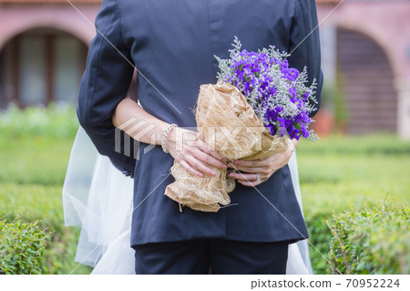 Newlyweds with a bouquet of beautiful flowers 70952224