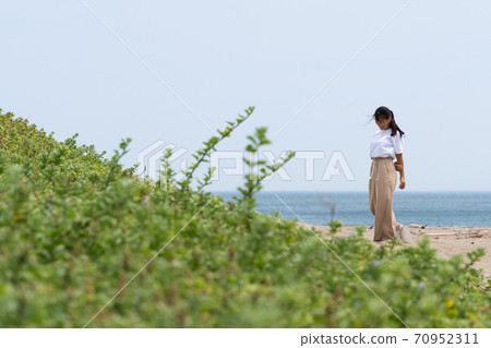 一個女人在沙灘上散步 70952311