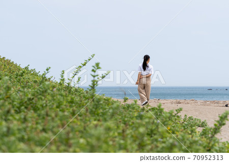 一個女人在沙灘上散步 70952313