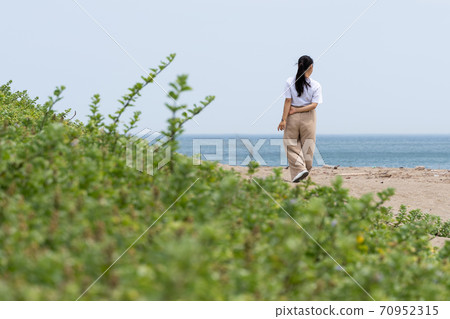 一個女人在沙灘上散步 70952315