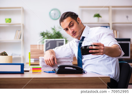 Young male employee working in the office Young male employee working in the office 70952995