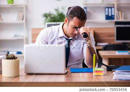 Young male employee working in the office Young male employee working in the office 70953456