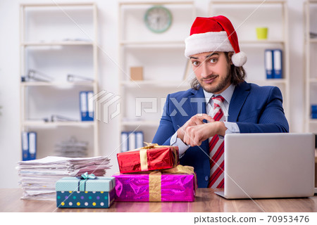 Young male employee working in the office at Christmas Eve 70953476