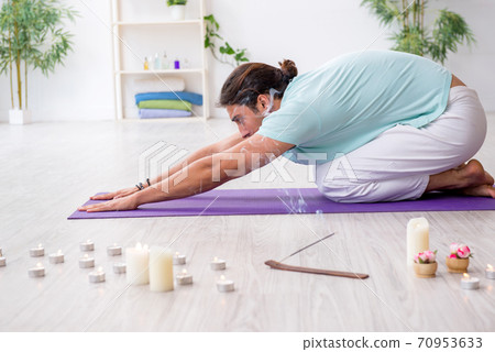 Young man during yoga session at home Young man during yoga session at home 70953633