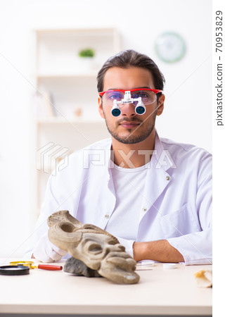 Young male archaeologist studying ancient african stonemask Young male archaeologist studying ancient african stonemask 70953829