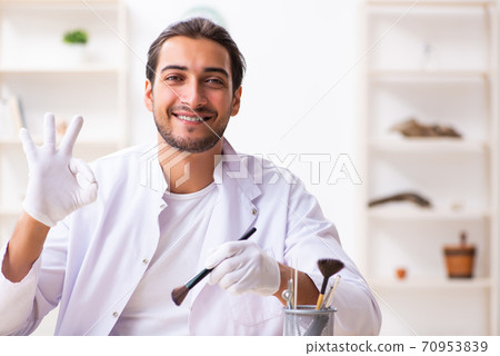 Young male archaeologist studying ancient african stonemask Young male archaeologist studying ancient african stonemask 70953839