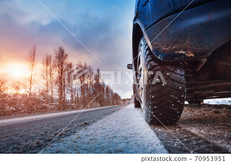Car tires on winter road covered with snow 70953951
