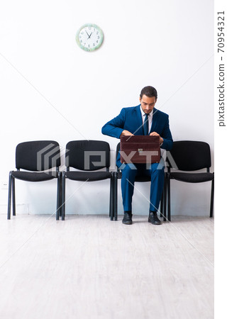 Young businessman waiting for an interview at hall Young businessman waiting for an interview at hall 70954321