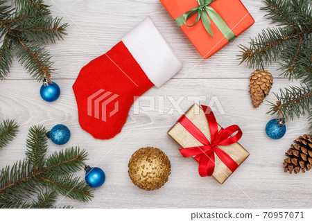 Santa's boot, gift box, fir tree branches with cones and christmas toys 70957071