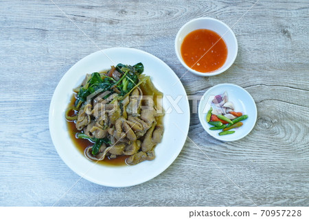 braised pork innards in black Chinese herb soup on plate dipping spicy sauce eat couple fresh chili and garlic braised pork innards in black Chinese herb soup on plate dipping spicy sauce eat couple fresh chili and garlic 70957228