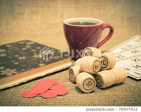 Wooden lotto barrels, cards, chips and cup of coffee on sackcloth. Wooden lotto barrels, cards, chips and cup of coffee on sackcloth. 70957422