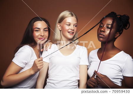 young pretty asian, caucasian, afro woman posing cheerful together on brown background, lifestyle diverse nationality people concept young pretty asian, caucasian, afro woman posing cheerful together on brown background, lifestyle diverse nationality people concept 70959430
