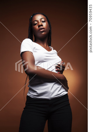 pretty young african american woman with braids posing cheerful gesturing on brown background, lifestyle people concept 70959435