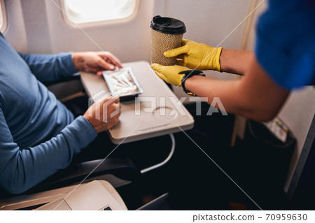 Coffee served to a passenger on the plane 70959630