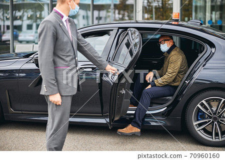 Man in eyeglasses getting out of the elite taxi 70960160