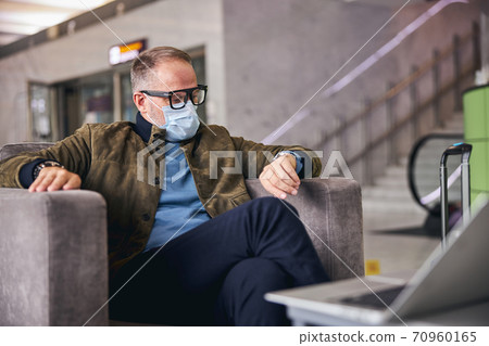 Focused man checking time on his watch 70960165