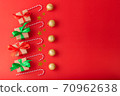 Christmas background, Christmas box with red ribbon and green ribbon, Christmas candy cane, gold ball and gold star on red background. Christmas background and Happy New Year for background 70962638