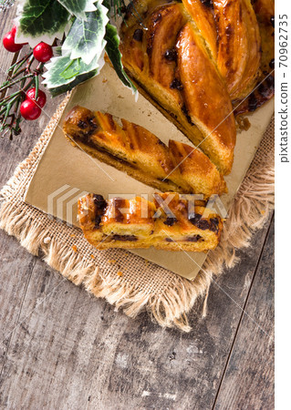 Homemade braid stuffed with chocolate and cut into pieces on wooden table. Flat lay top-down composition 70962735