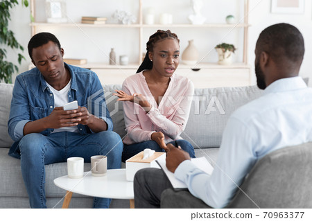 Smartphone Addiction. Annoyed African Wife Complaining About Indifferent Husband To Family Counselor 70963377