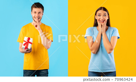 Happy man holding gift box at studio, excited woman waiting 70963424