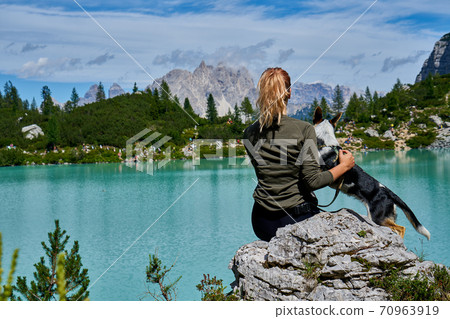 young woman and her dog hiking to the top of a mountain. Pandemic covid isolation young woman and her dog hiking to the top of a mountain. Pandemic covid isolation 70963919