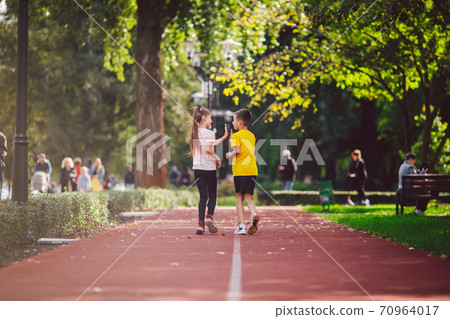 Kids run. Healthy sport. Child sport, heterosexual twins running on track, fitness. Joint training. Running training outdoor brother and sister pre-teen. Jogging with friend. Children athletes Kids run. Healthy sport. Child sport, heterosexual twins running on track, fitness. Joint training. Running training outdoor brother and sister pre-teen. Jogging with friend. Children athletes 70964017