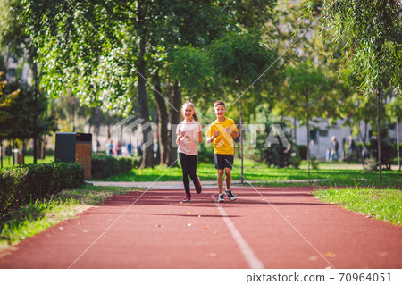 Child fitness, twins kids running on stadium track in city park , training and children sport healthy lifestyle. Outdoor activities by running make the child's body healthy and experience enriched Child fitness, twins kids running on stadium track in city park , training and children sport healthy lifestyle. Outdoor activities by running make the child's body healthy and experience enriched 70964051