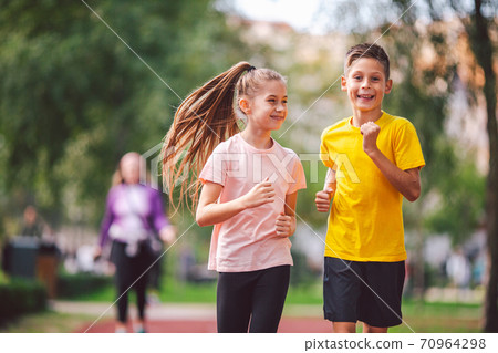 Kids run. Healthy sport. Child sport, heterosexual twins running on track, fitness. Joint training. Running training outdoor brother and sister pre-teen. Jogging with friend. Children athletes 70964298