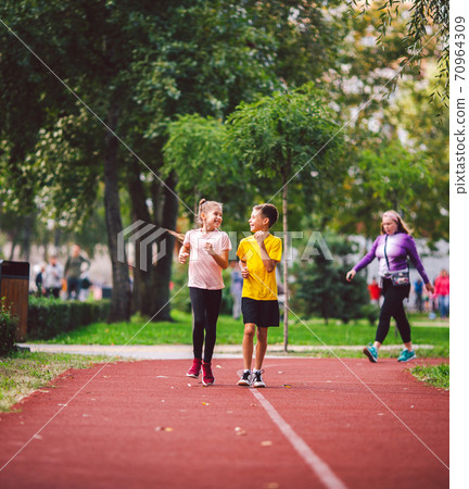 Kids run. Healthy sport. Child sport, heterosexual twins running on track, fitness. Joint training. Running training outdoor brother and sister pre-teen. Jogging with friend. Children athletes Kids run. Healthy sport. Child sport, heterosexual twins running on track, fitness. Joint training. Running training outdoor brother and sister pre-teen. Jogging with friend. Children athletes 70964309