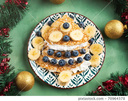 Christmas tree shaped crepes with blueberry, quark 70964378