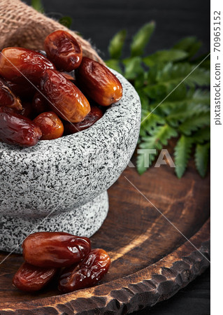 Bowl of dried dates on dark wooden background Bowl of dried dates on dark wooden background 70965152