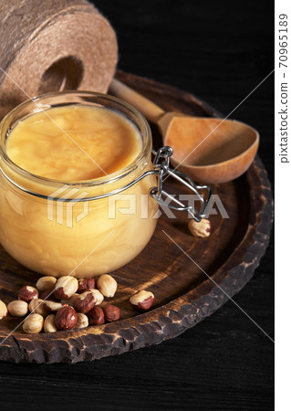 Honey background. Sweet honey in the comb, glass jar with nuts. On wooden background. Honey background. Sweet honey in the comb, glass jar with nuts. On wooden background. 70965189