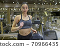 Woman Running on Treadmill 70966435