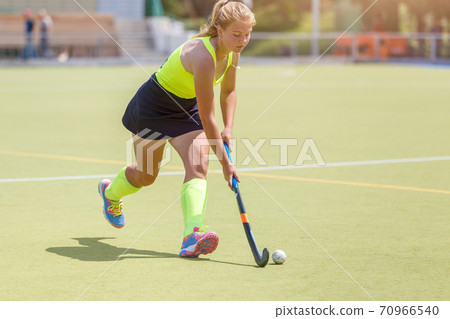 Younf female hockey player leading the ball 70966540
