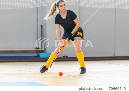 Young woman player in attack at indoor hockey match Young woman player in attack at indoor hockey match 70966543