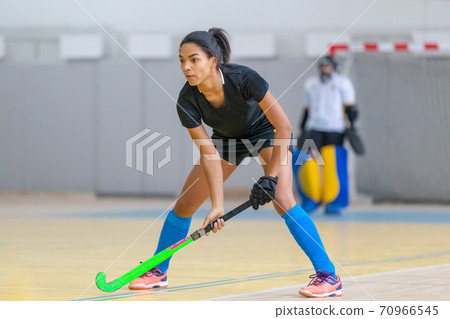 Young female hockey player in defence at the match 70966545